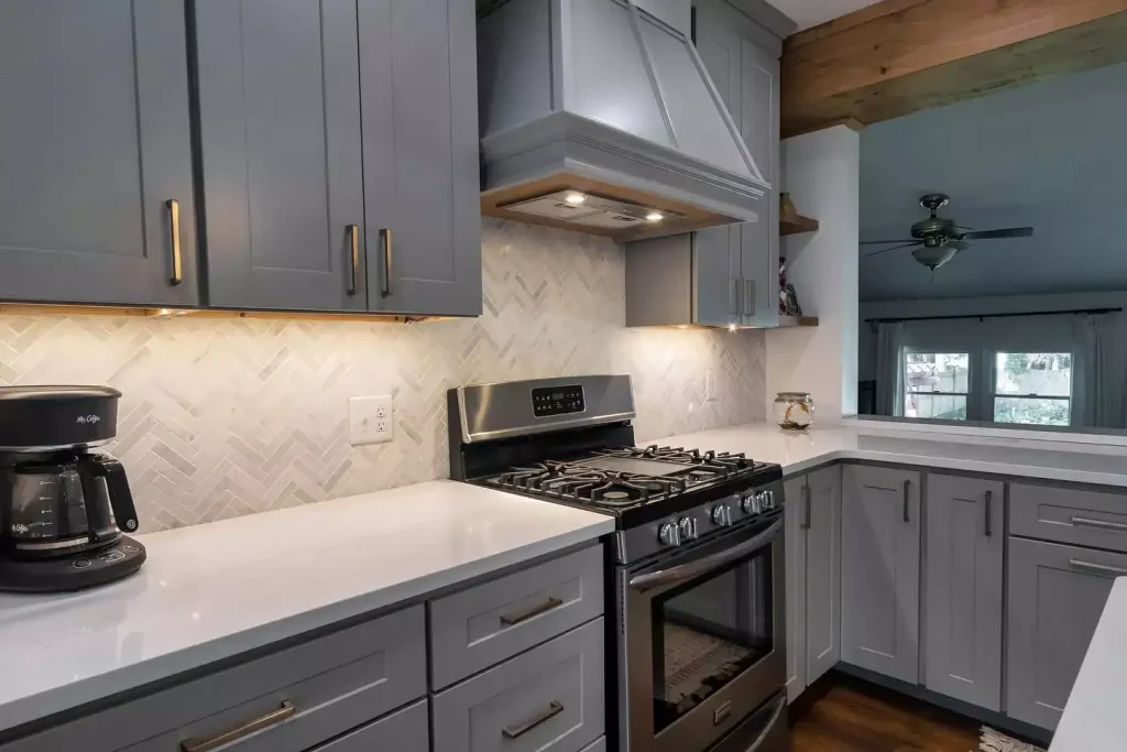 Countertops, range, and range hood. Modern kitchen with natural elements by Stately Kitchen and Bath in Amherst, NY.