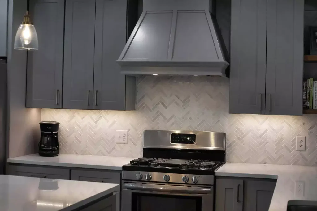 Range and range hood. Modern kitchen with natural elements by Stately Kitchen and Bath in Amherst, NY.