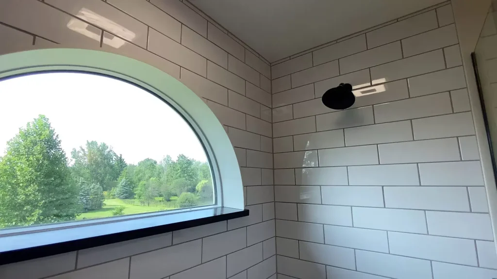 Seemless shower tile and integrated window by Stately Kitchen and Bath in Clarence, NY.