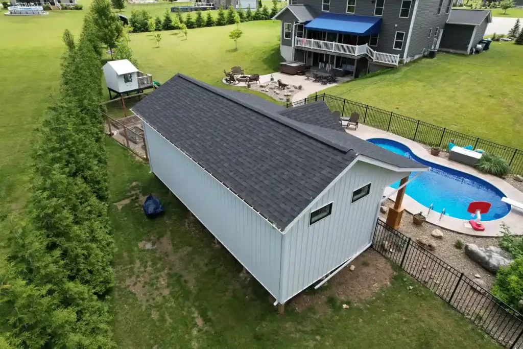 Rear view of the pool house addition in Akron, NY, showcasing the building's structure and proximity to the pool, designed by Stately General Contracting.