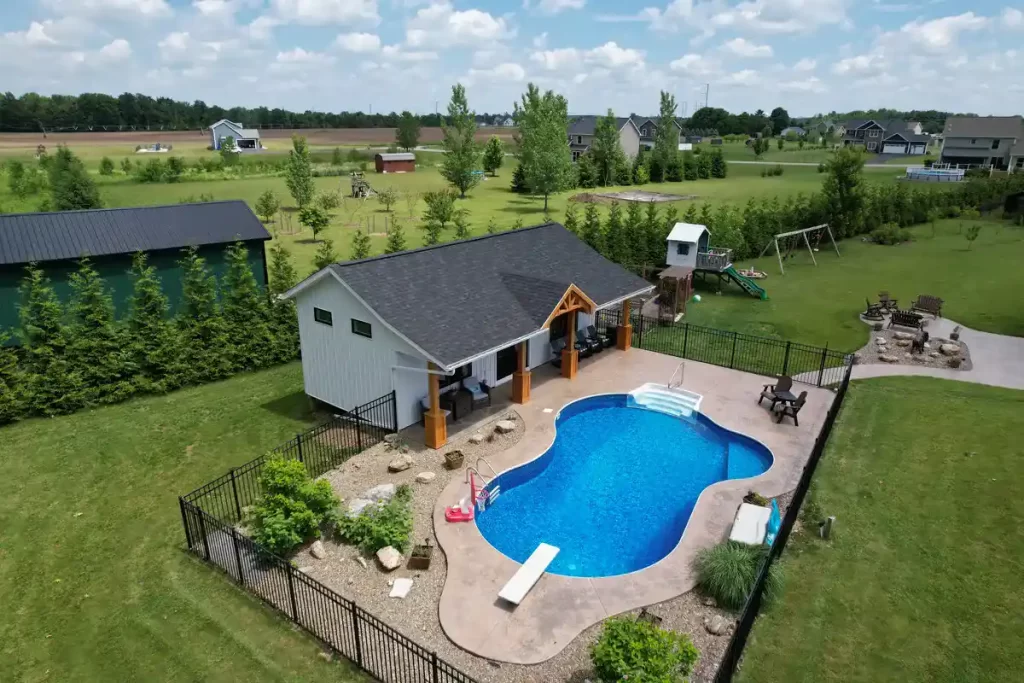 Side view of the pool house addition in Akron, NY, showcasing the overhang with custom millwork and the pool area, designed by Stately General Contracting.