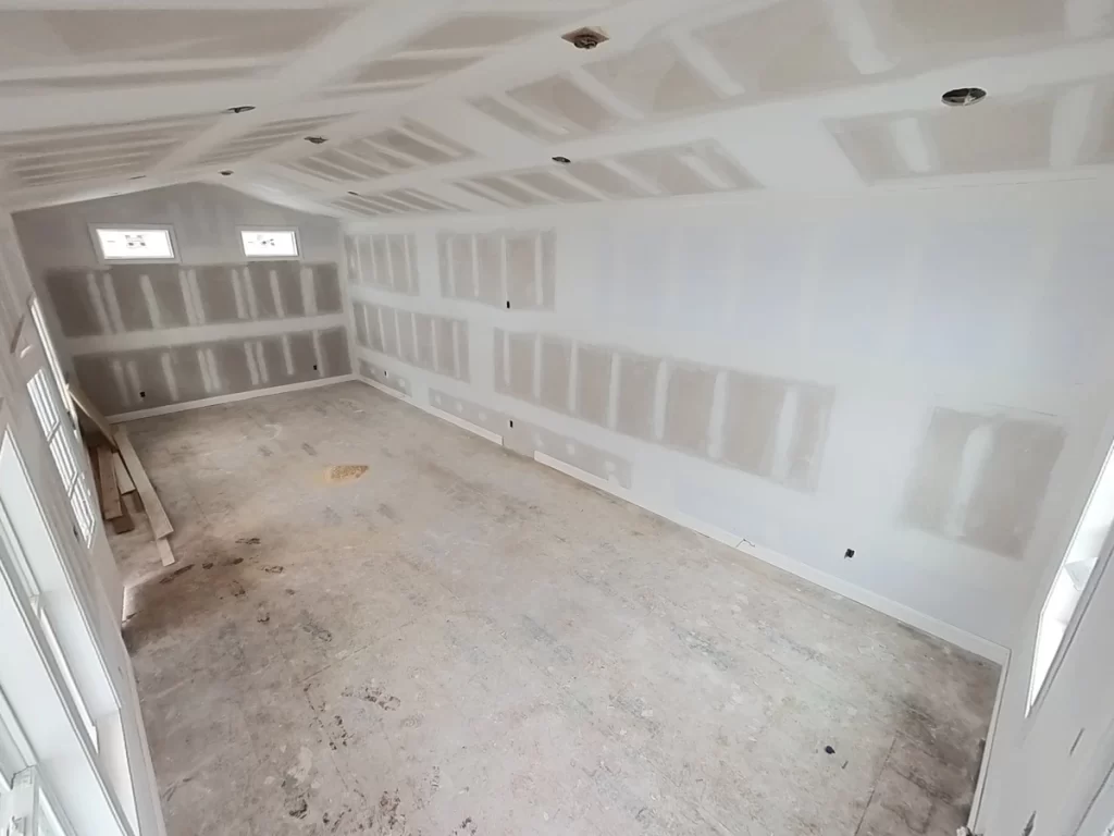 Interior of pool house with drywall installed, showcasing construction progress.