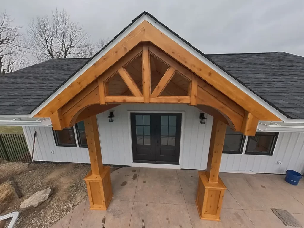 Close-up view of the timber truss and wooden porch of the newly constructed pool house, showing craftsmanship and design.