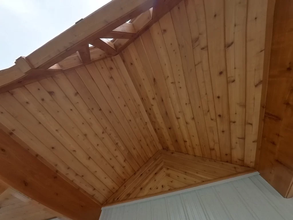 Detailed view of the wooden ceiling on the porch of the pool house, highlighting the natural wood finish and construction.