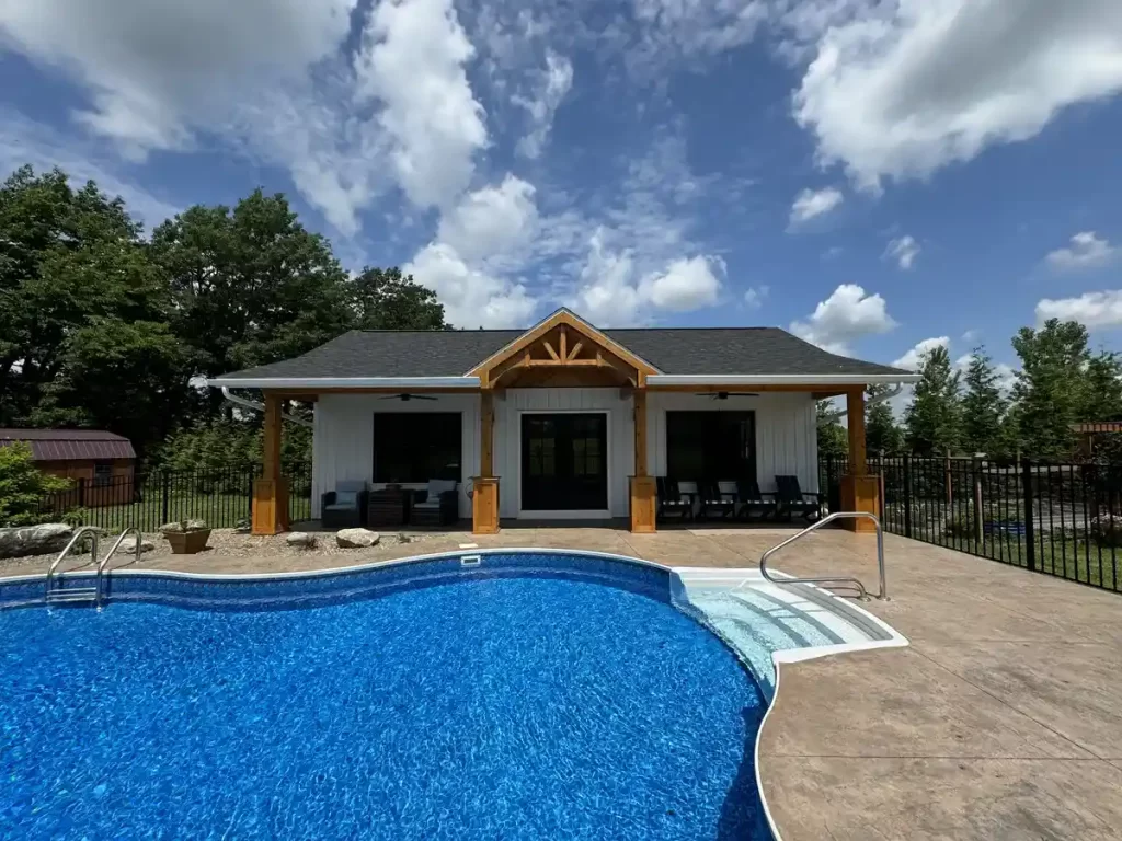 Front view of the pool house addition in Akron, NY, showcasing the pool, overhang with custom millwork, and seating area, designed by Stately General Contracting.