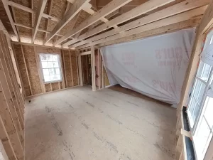 Stately General Contracting home addition in Clarence, NY, showing the primary bedroom under construction with framed walls and windows.