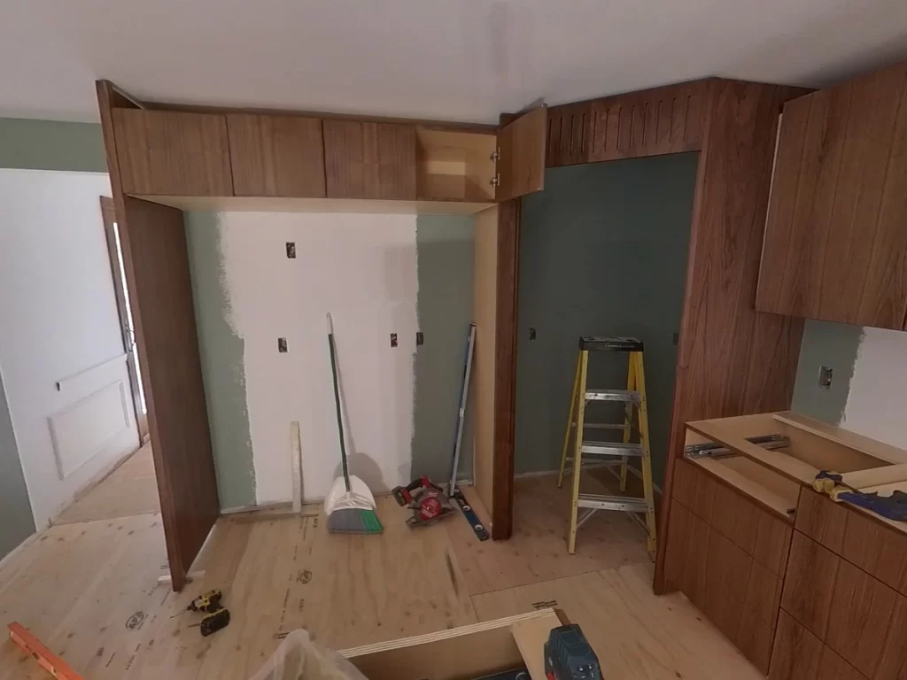 Cabinet installation progress with open shelving by Stately Kitchen and Bath.