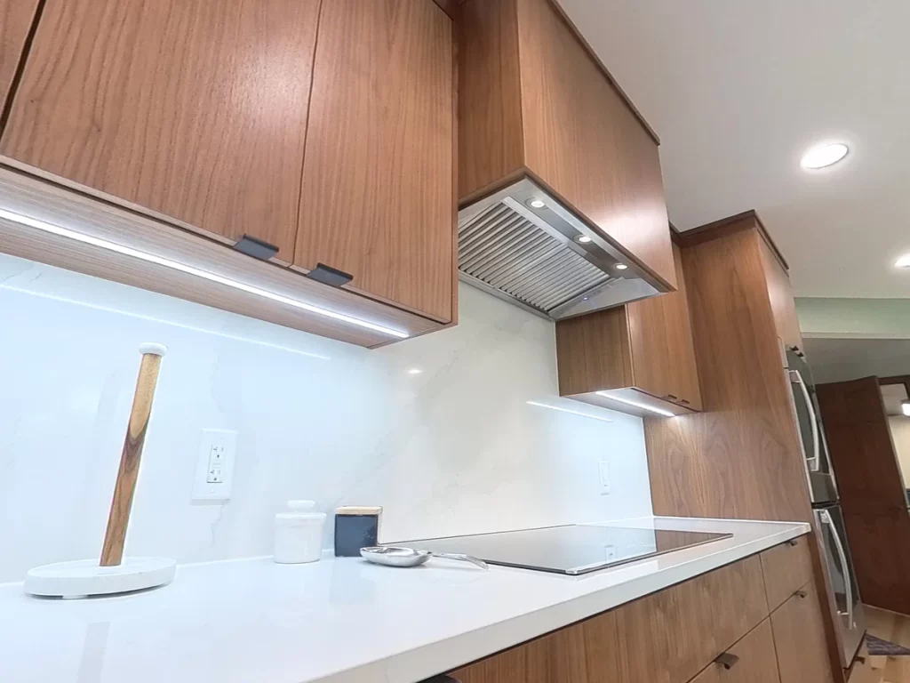 Close-up of custom cabinets and under-cabinet lighting in remodeled kitchen by Stately Kitchen and Bath.