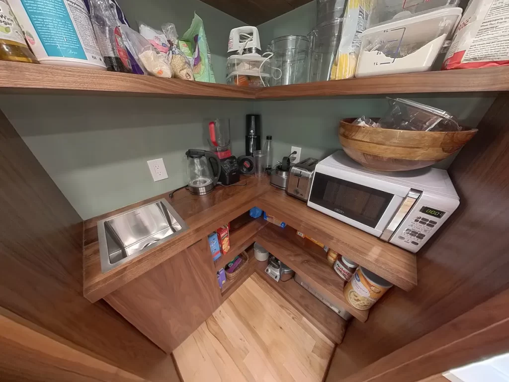 Organized pantry with sink and microwave in remodeled kitchen by Stately Kitchen and Bath.