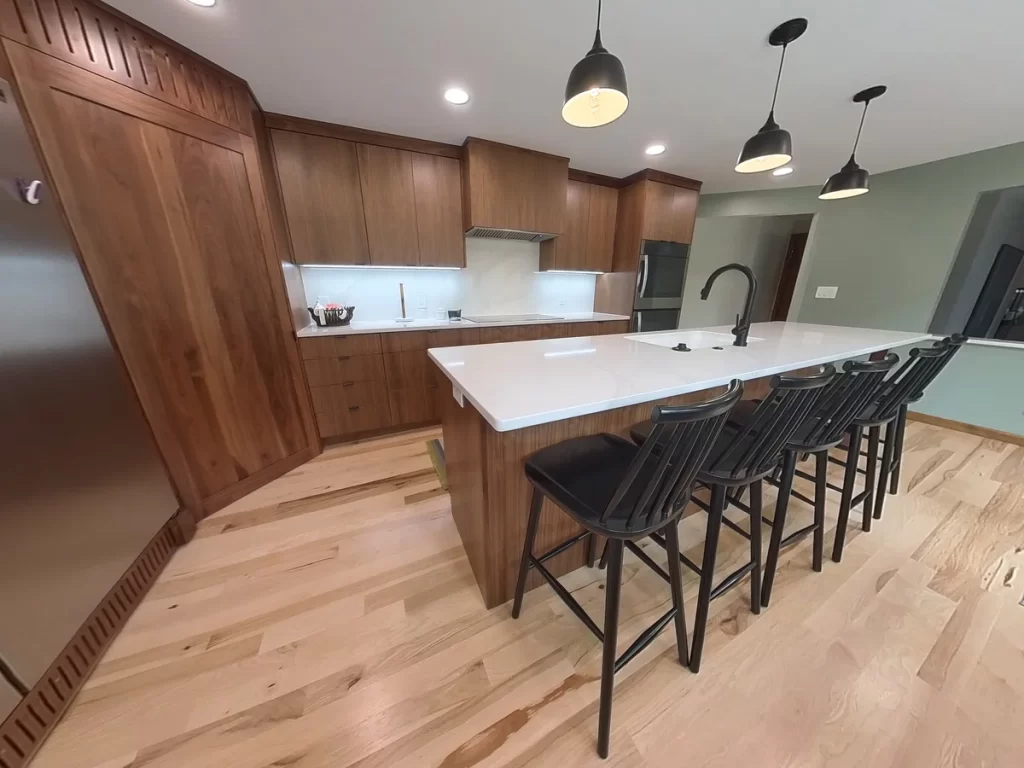 Modern kitchen remodel with island seating and pendant lighting by Stately Kitchen and Bath.