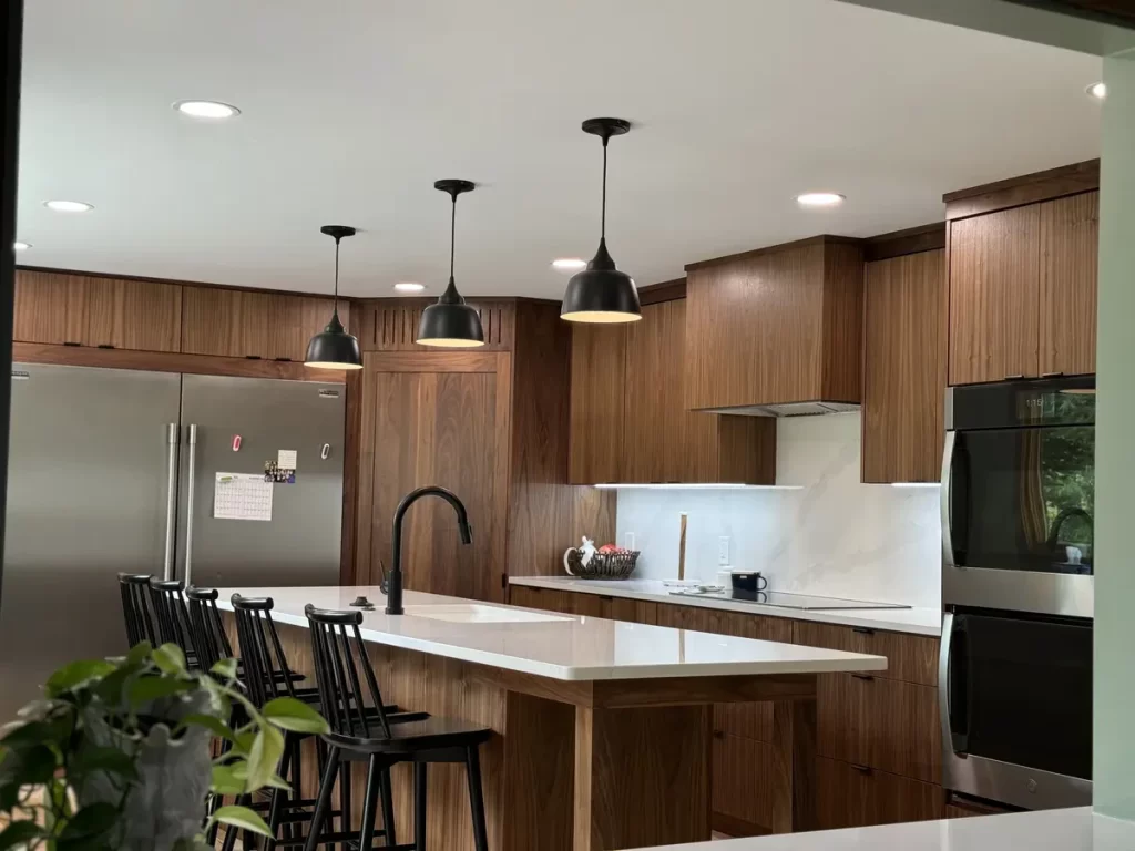 Renovated kitchen with island, modern lighting, and new appliances in Buffalo, NY after Stately Kitchen Remodel.