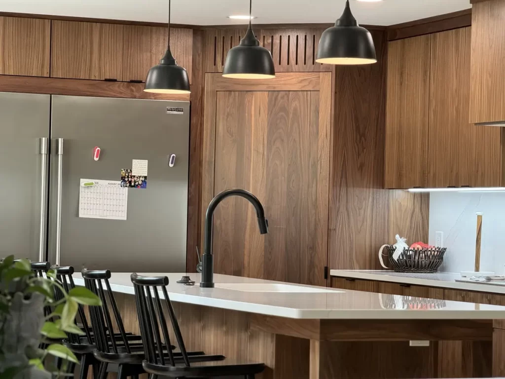 Renovated kitchen with island, modern lighting, and new appliances in Buffalo, NY after Stately Kitchen Remodel.