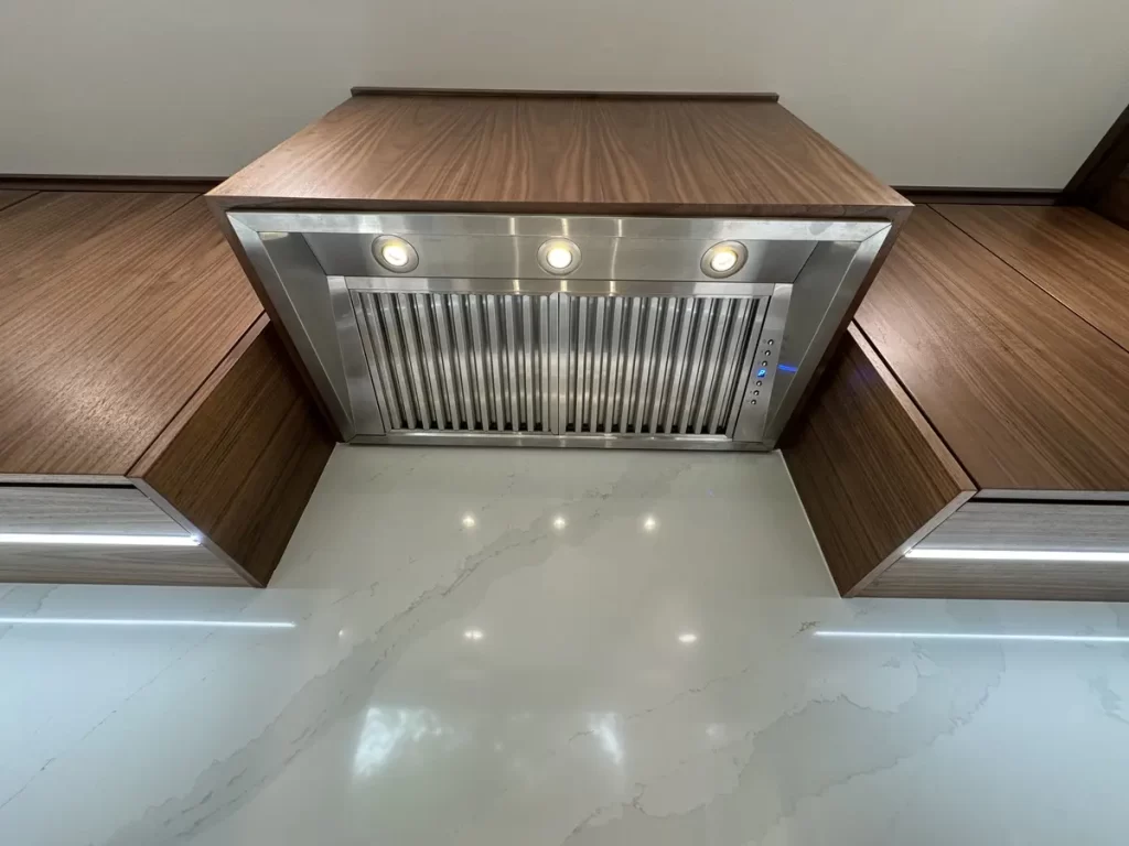 Close-up of range hood and cabinetry in modern kitchen in Buffalo, NY after Stately Kitchen Remodel.