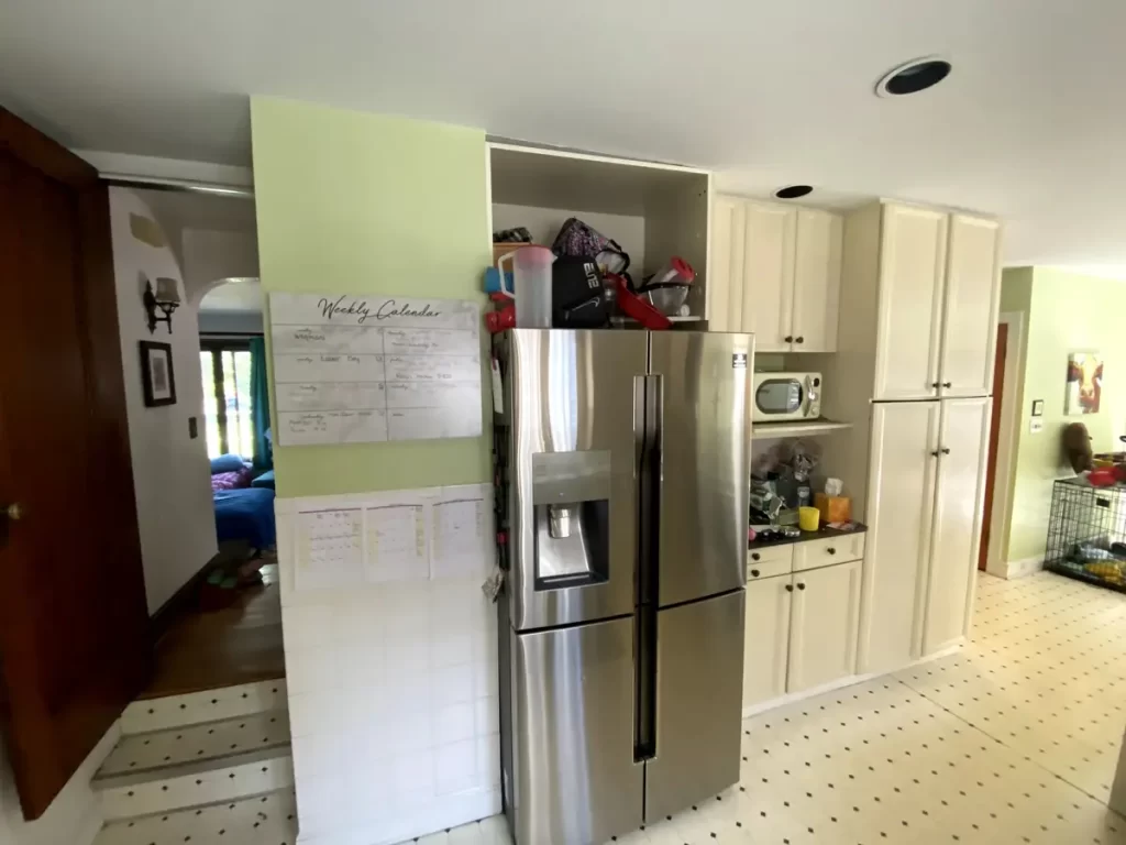 Kitchen featuring stainless steel appliances and white cabinets in Buffalo, NY before renovation.