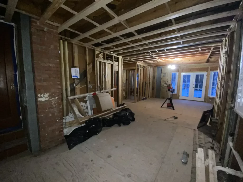 Framing stage of kitchen remodel in Amherst, NY, showing exposed beams and wiring by Stately Kitchen and Bath.