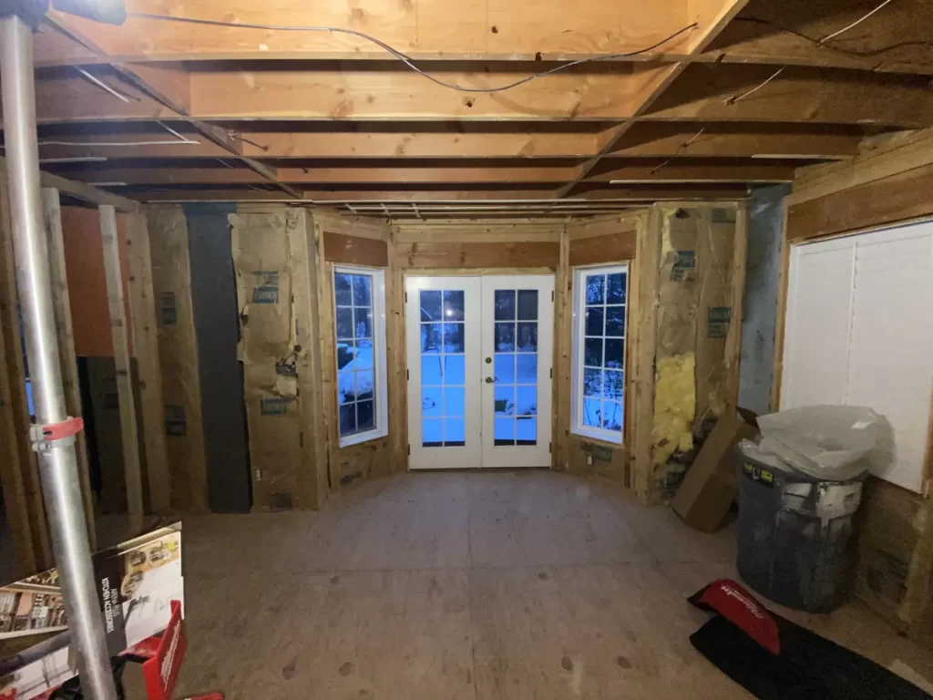 Kitchen remodel in Amherst, NY - construction stage with exposed ceiling beams and newly framed doorway.