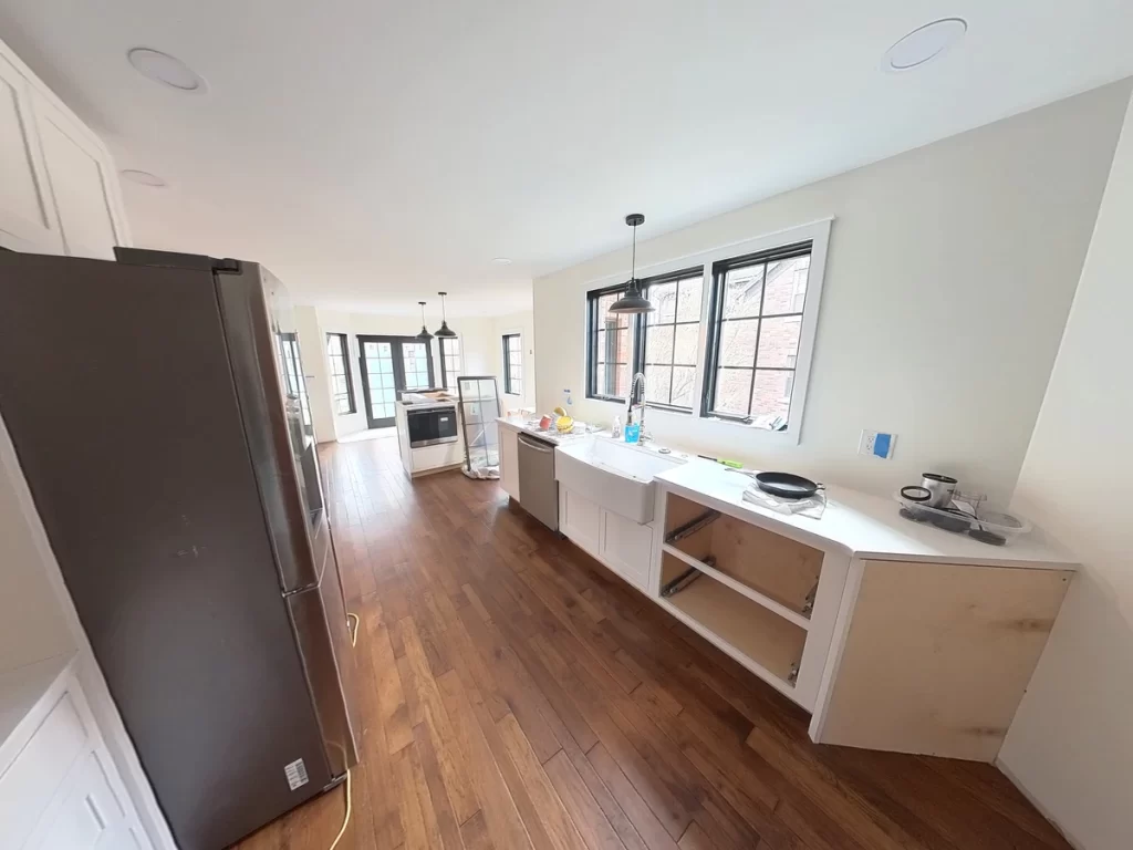 View of the kitchen remodel with new white cabinets and wood flooring, Amherst NY.