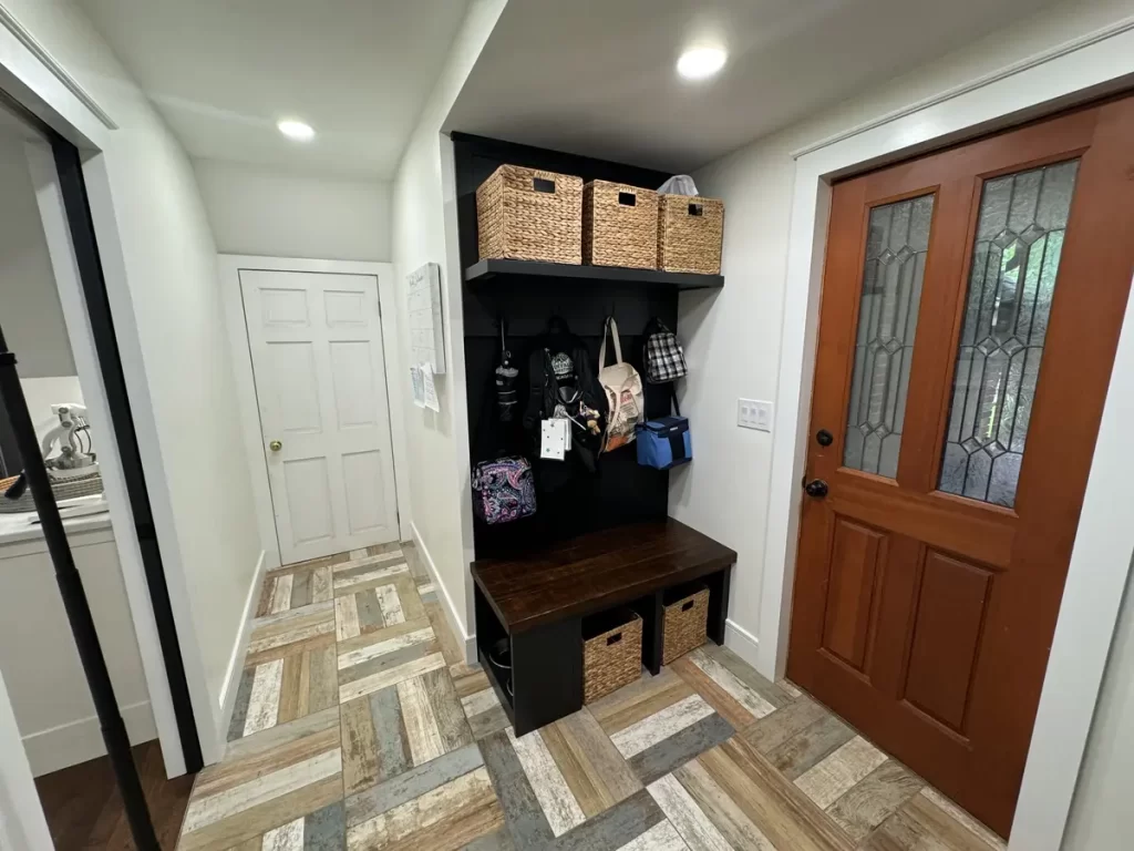 Renovated mudroom with built-in storage and wooden door in Amherst, NY after remodeling by Stately Kitchen and Bath.