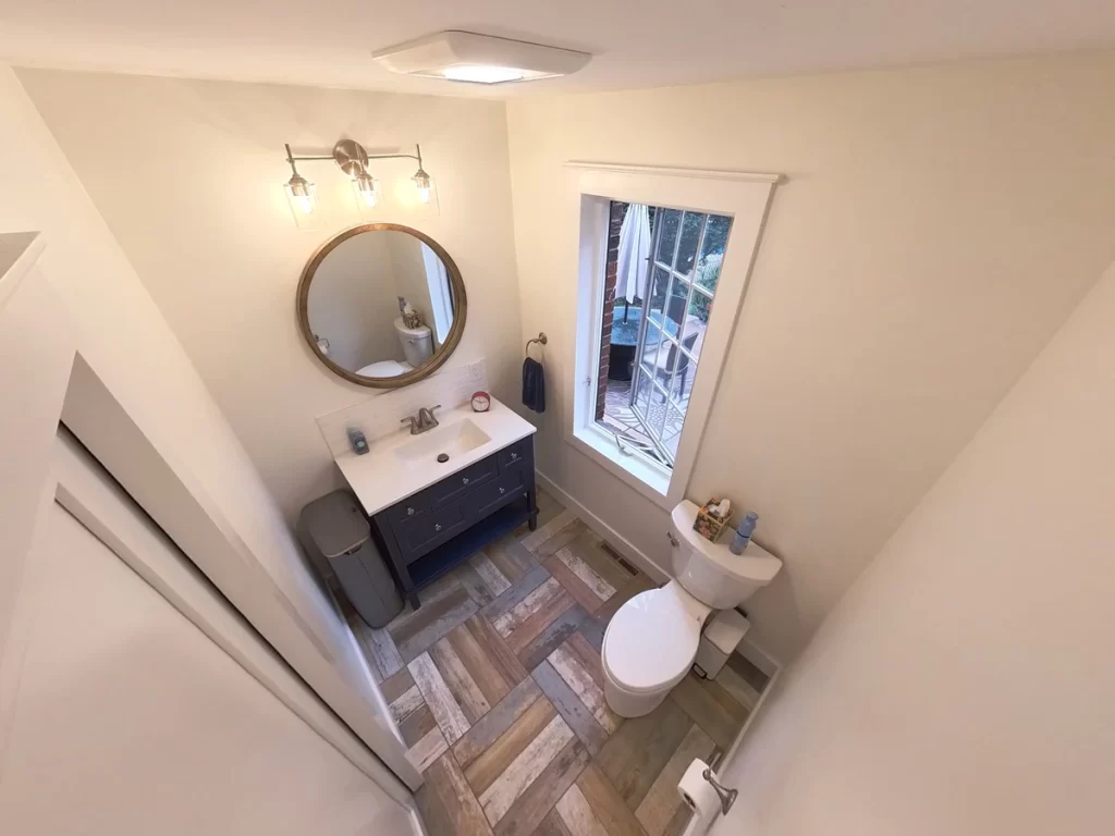 Aerial view of renovated bathroom with dark vanity and natural light in Amherst, NY by Stately Kitchen and Bath.