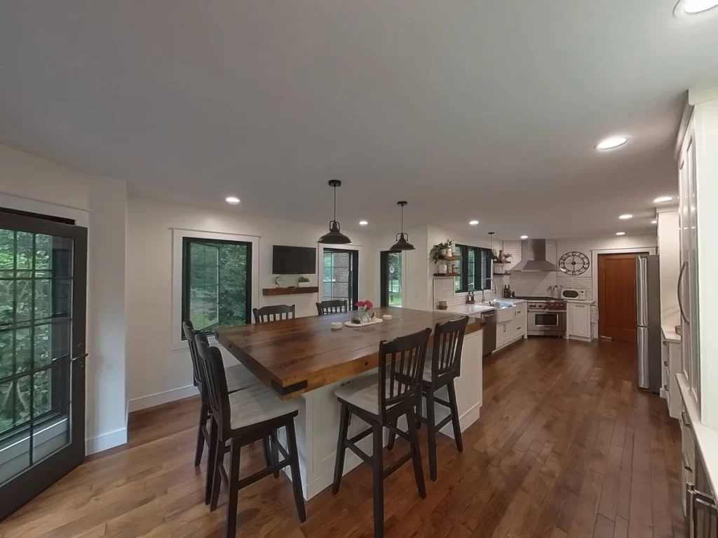 Open kitchen and dining area with wooden island and modern appliances in Amherst, NY after remodel by Stately Kitchen and Bath.