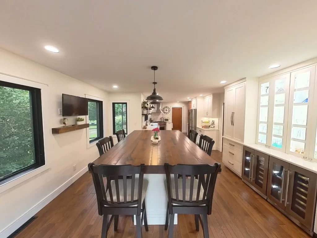 Spacious open kitchen and dining area with wooden island and modern cabinetry in Amherst, NY after remodel by Stately Kitchen and Bath.