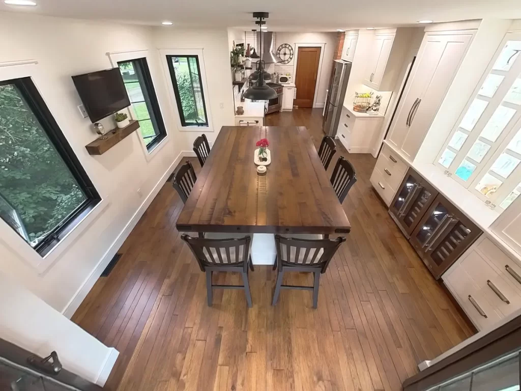 Aerial view of remodeled kitchen and dining area with wooden island and elegant lighting in Amherst, NY by Stately Kitchen and Bath.