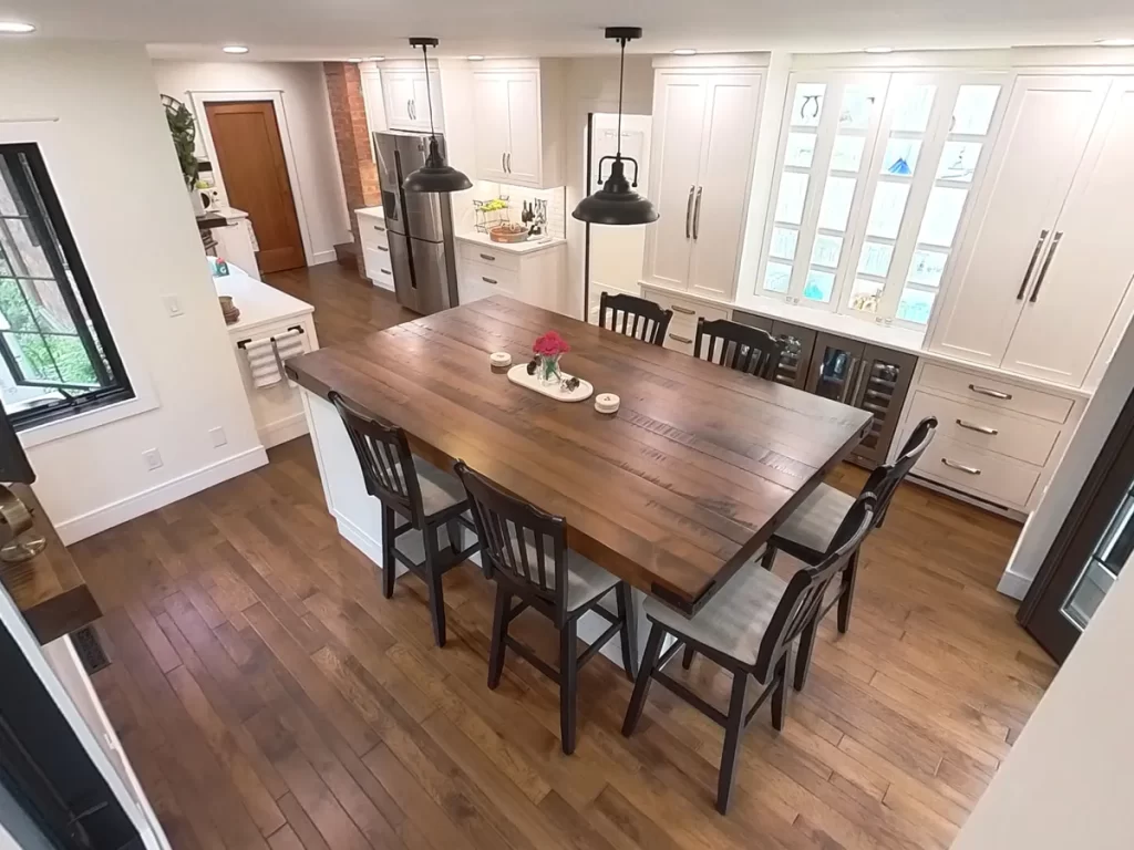 Large kitchen island with chairs and modern lighting in Amherst, NY after renovation by Stately Kitchen and Bath.