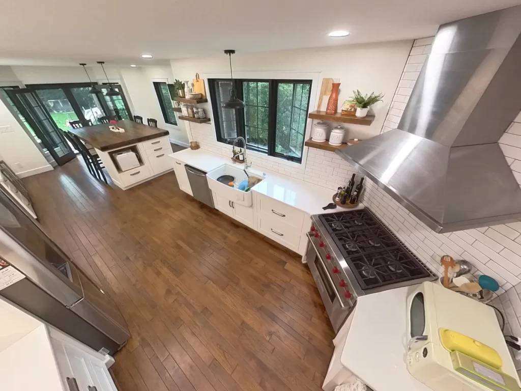 Aerial view of modern kitchen with stainless steel appliances and large wooden island in Amherst, NY after renovation by Stately Kitchen and Bath.