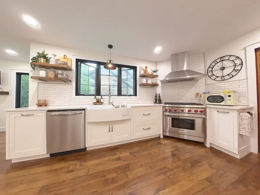 Modern kitchen with subway tile backsplash, stainless steel range, and farmhouse sink in Amherst, NY after renovation by Stately Kitchen and Bath.