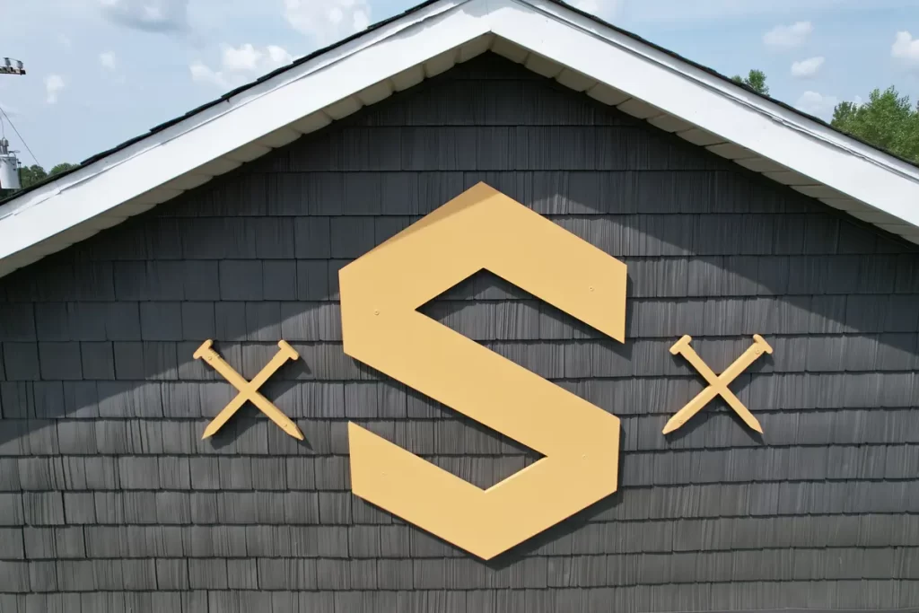 Close-up of Stately Builders logo on newly installed siding after office exterior remodel in Clarence Center.