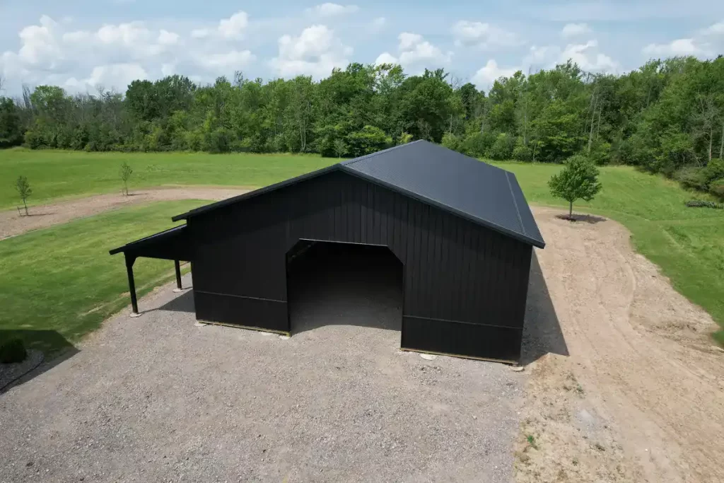 Aerial view of a 40x60 matte black pole barn in Clarence, NY, showcasing Stately Pole Barns' durable construction with Perma-Column Sturdi-Wall Brackets and Everlast II Steel Panels.