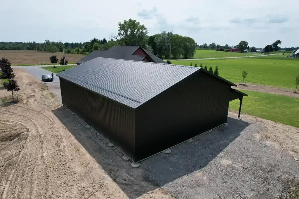 Side view of a 40x60 matte black pole barn in Clarence, NY, built by Stately Pole Barns with durable Everlast II Steel Panels and a precision-engineered roof structure.