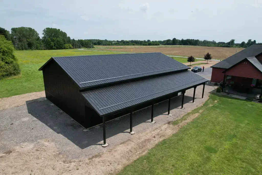 Overhead view of a matte black 40x60 pole barn in Clarence, NY, featuring a sleek design with a covered porch area built by Stately Pole Barns.