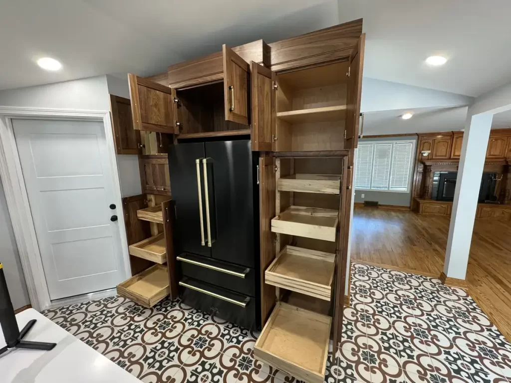 Post-remodel kitchen in Elma, NY, featuring bold patterned tile flooring, sleek black appliances, and plenty of storage options.