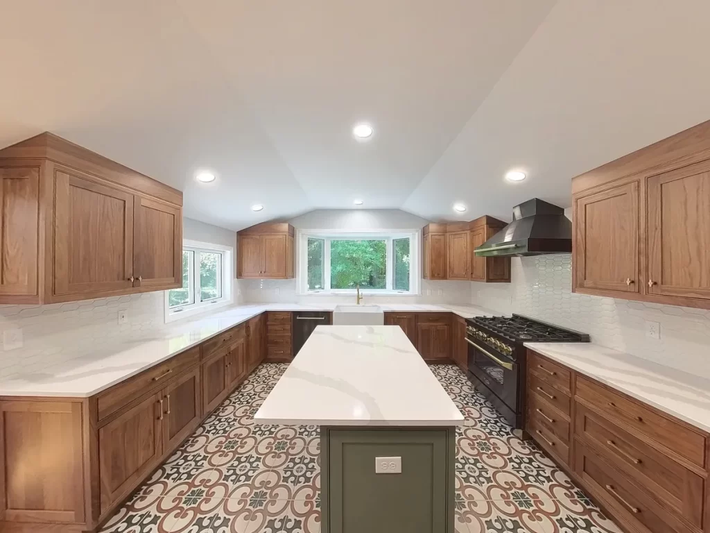 Modern kitchen after remodel in Elma, NY, showcasing custom cabinets, bright recessed lighting, and bold patterned tile flooring.