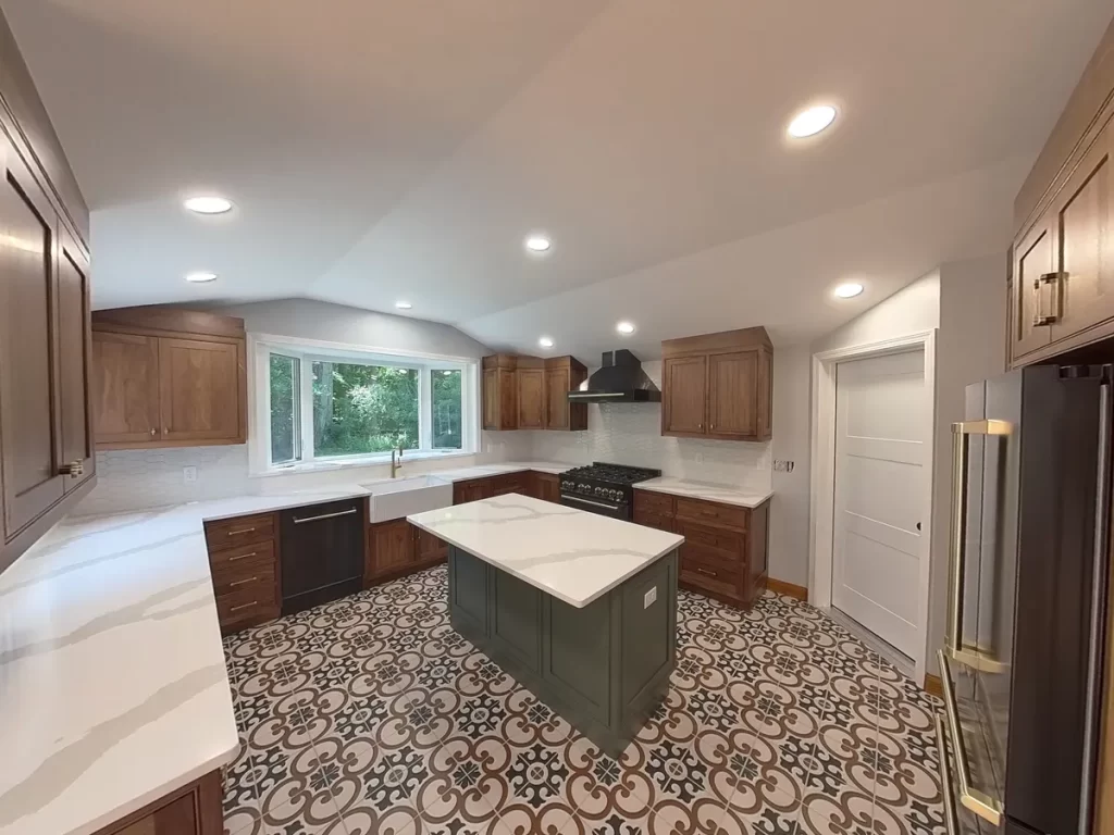 Elma, NY, kitchen post-remodel featuring a custom island with built-in storage, surrounded by wooden cabinetry and patterned tile flooring.