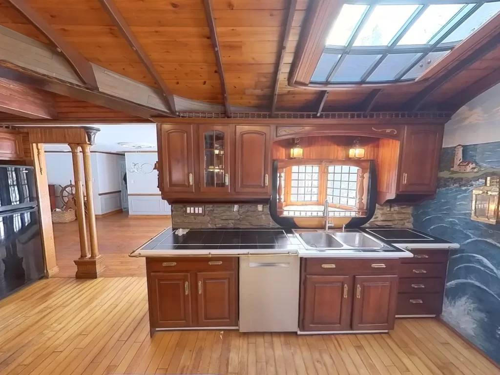 Image of a ship-themed kitchen in Elma, NY, showing the island with dark wood finishes and extensive nautical-themed decor.