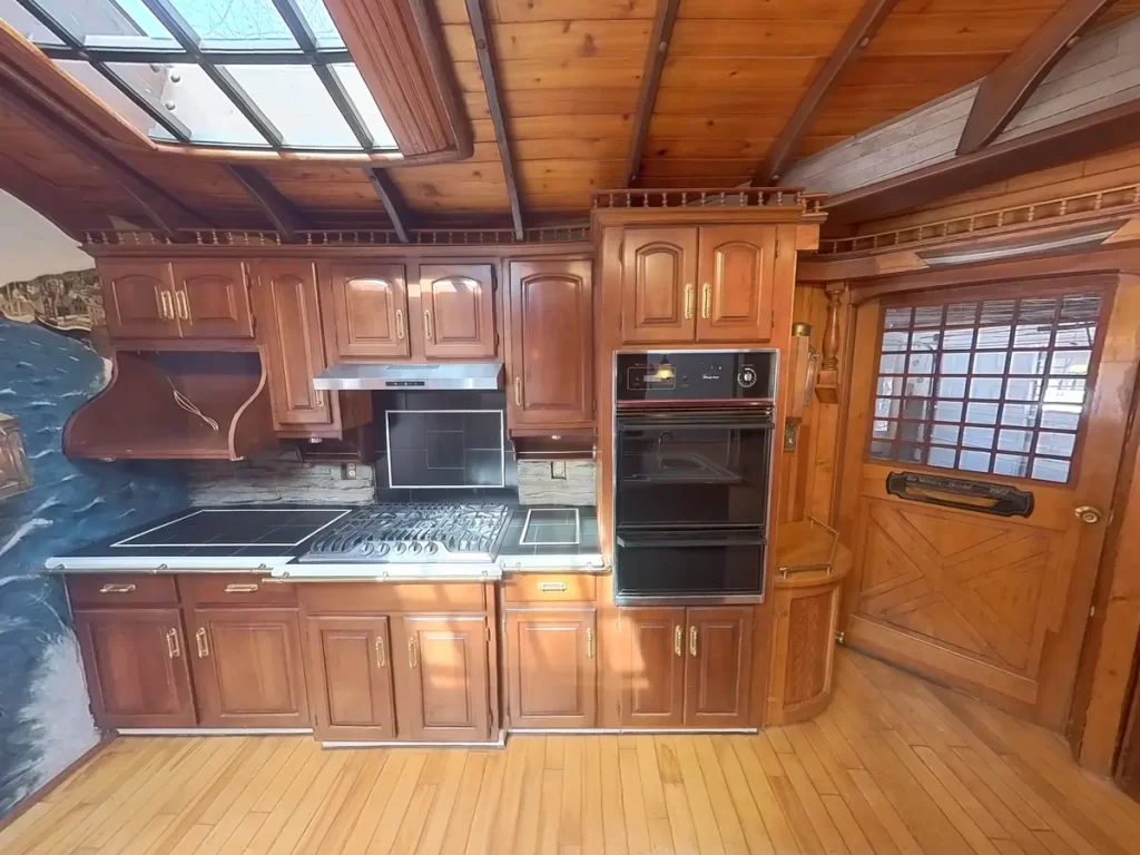 Image of a ship-themed kitchen in Elma, NY, showing the island with dark wood finishes and extensive nautical-themed decor.