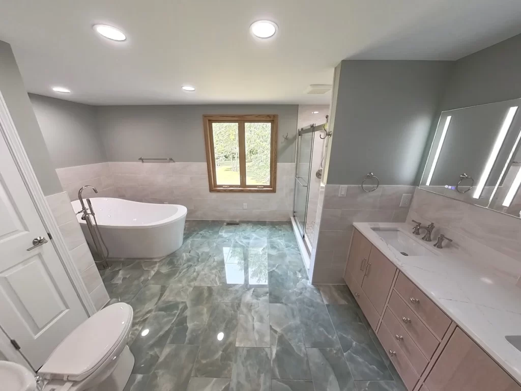 Wide-angle view of a modern bathroom, built by Stately Kitchen and Bath, with a freestanding soaking tub, large walk-in shower, and custom vanity.