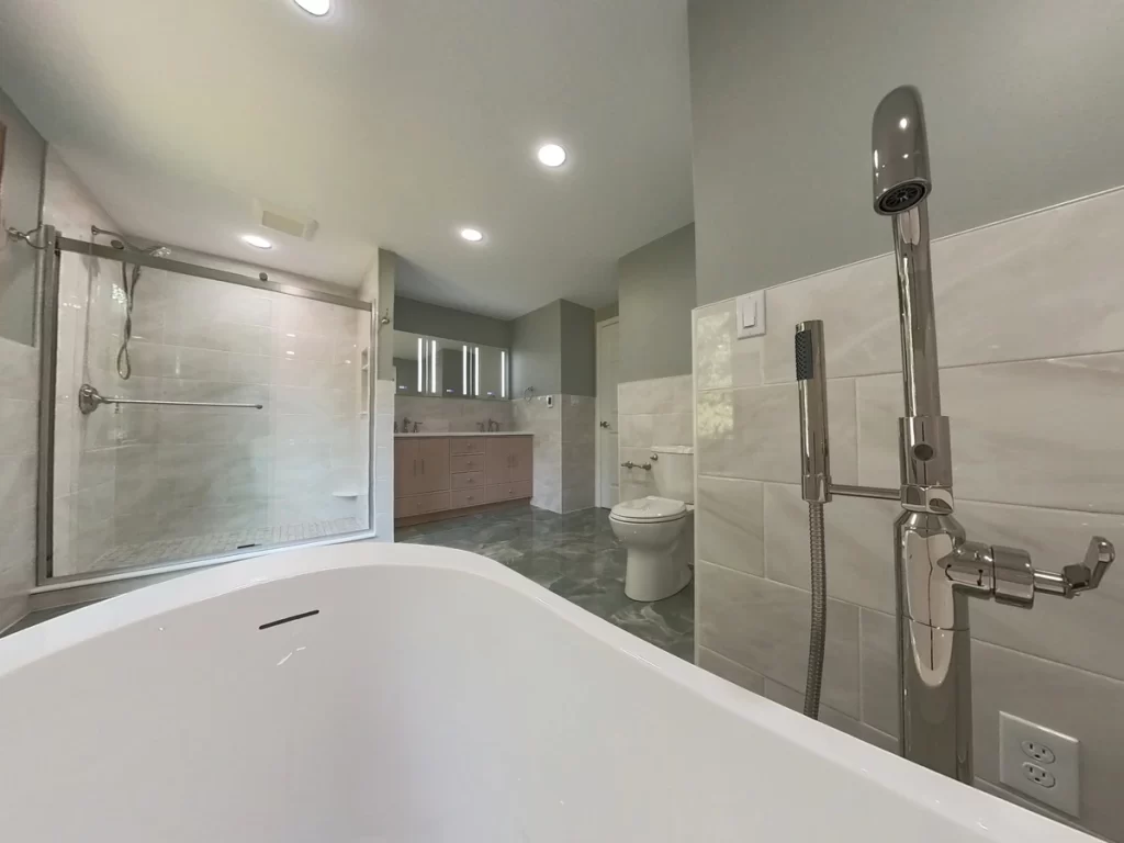 A wide-angle view from the bathtub looking toward the shower and vanity in a modern bathroom remodel by Stately Kitchen and Bath with a clean, minimalist design.