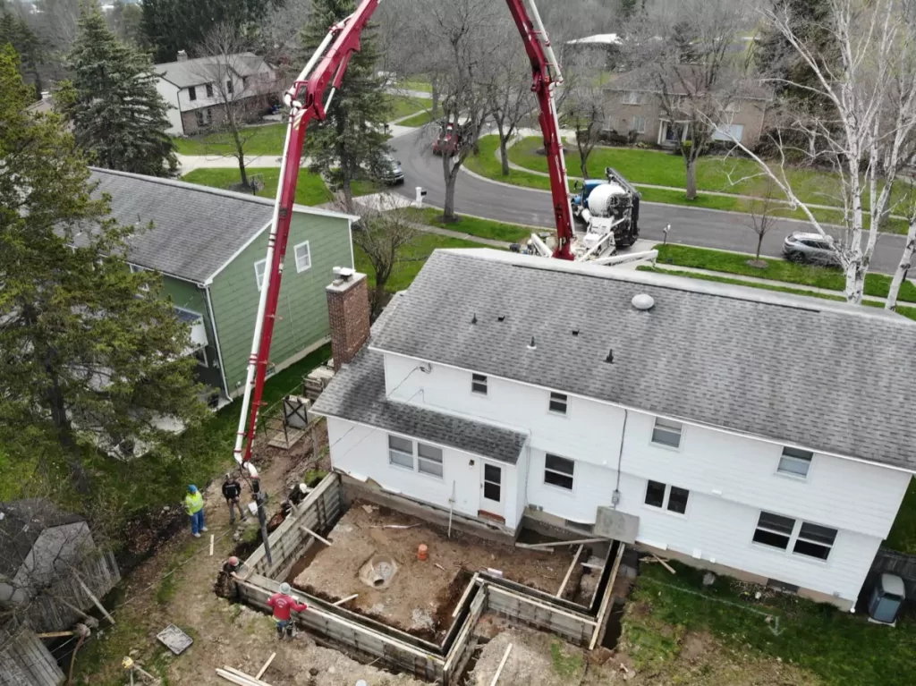 Aerial view of concrete foundation work for home addition in Amherst, NY, showcasing Stately’s efficient project setup.