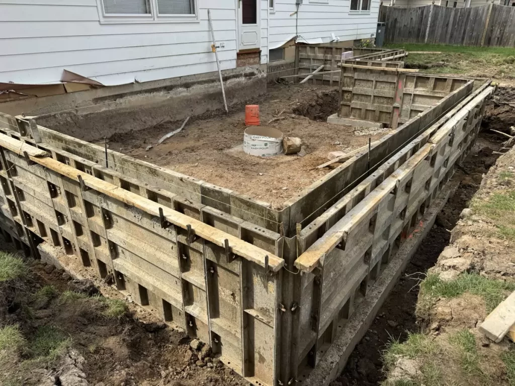 Detailed view of concrete forms set for foundation work on a Stately General Contracting home addition project.