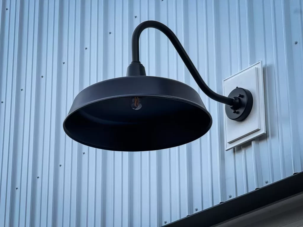 Modern black gooseneck barn light on a Stately pole barn, highlighting functional and aesthetic design features in Holland, NY.