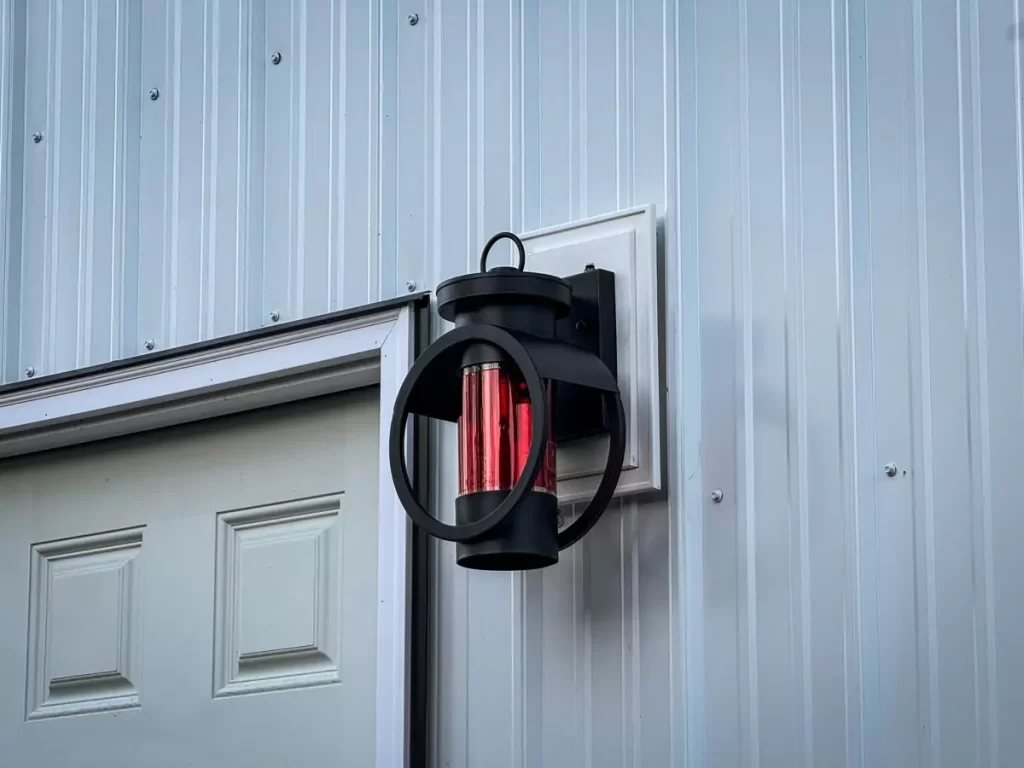 Stylish lantern light with red glass on a Stately pole barn, demonstrating unique design elements and craftsmanship in Holland, NY.