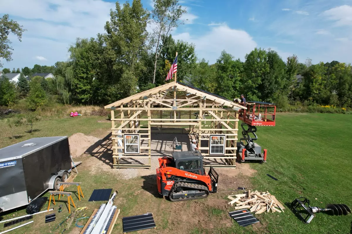 Stately Pole Barn framework with roof trusses set in place, highlighting structure’s quality and durability.