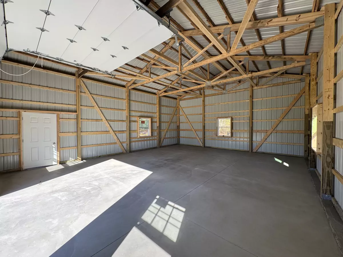 Interior of Stately Pole Barn showcasing spacious layout with concrete flooring and metal wall panels.