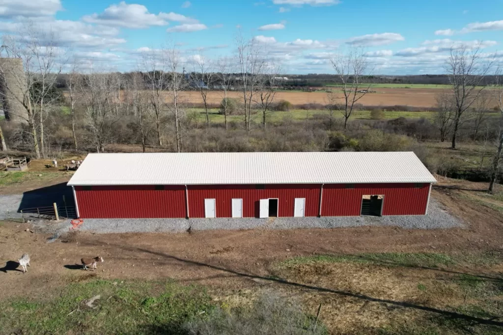 Overhead view of red agricultural pole barn in Gasport, NY, showcasing spacious 120x32 structure and scenic surroundings.