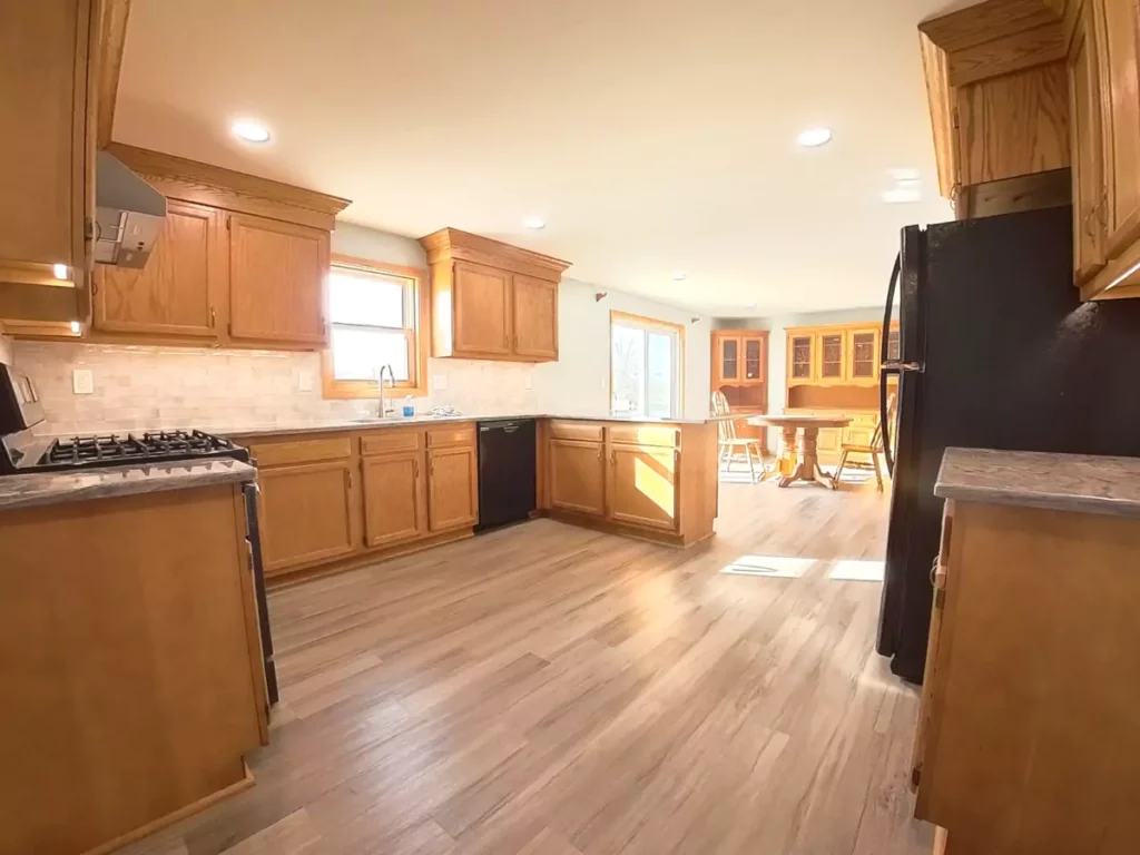 Stately kitchen remodel in Akron, NY featuring luxury vinyl plank flooring and modern recessed lighting.