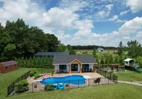 Aerial view of the pool house addition in Akron, NY, showcasing the surrounding landscape and custom millwork details by Stately General Contracting.