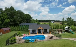 Aerial view of the pool house addition in Akron, NY, showcasing the surrounding landscape and custom millwork details by Stately General Contracting.